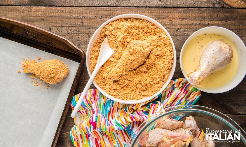 dipping chicken in egg mixture then breading and placing on a baking sheet