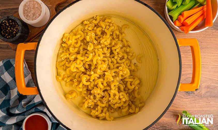 adding cooked elbow macaroni to cheese sauce