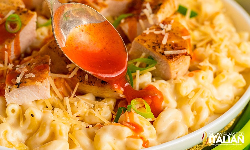 drizzling mac and cheese and chicken with buffalo sauce