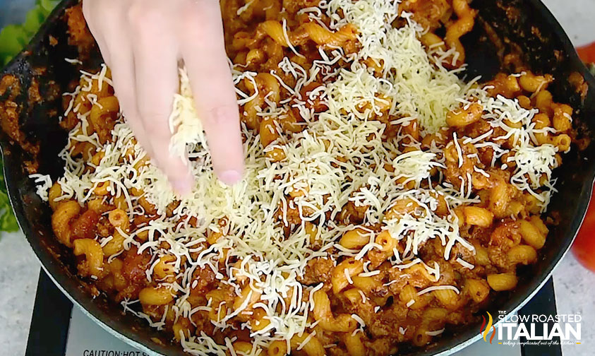 adding shredded cheese to american goulash