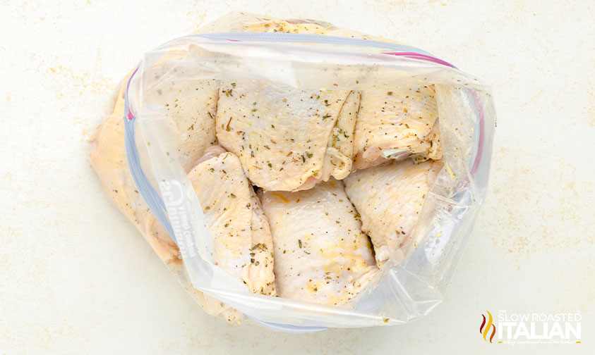 seasoned chicken thighs in a resealable plastic bag with marinade