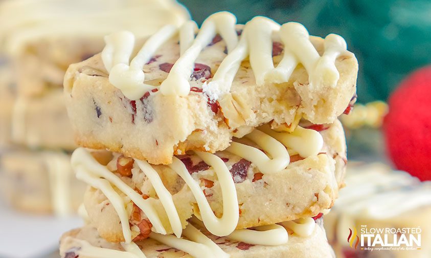 stack of cranberry shortbread biscuits drizzled with white chocolate