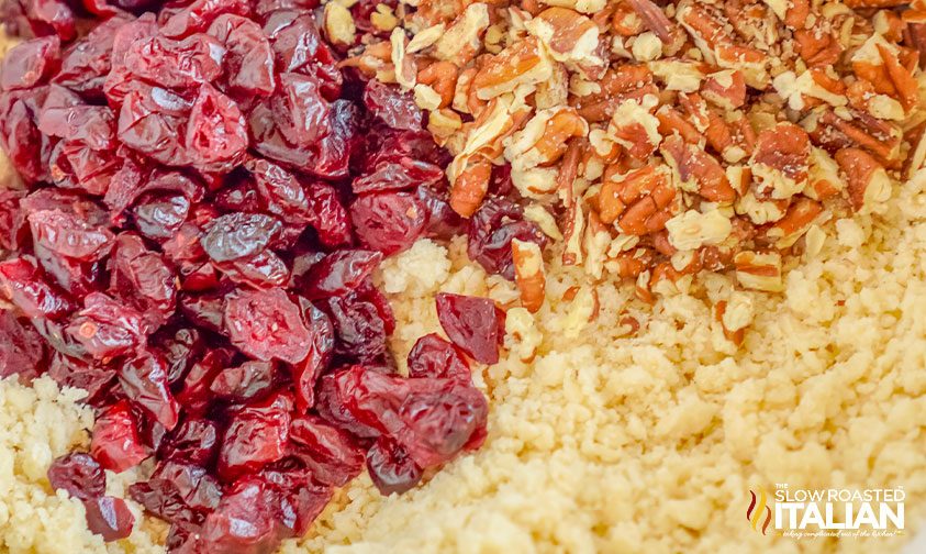 close up: dried cranberries and chopped pecans over shortbread dough