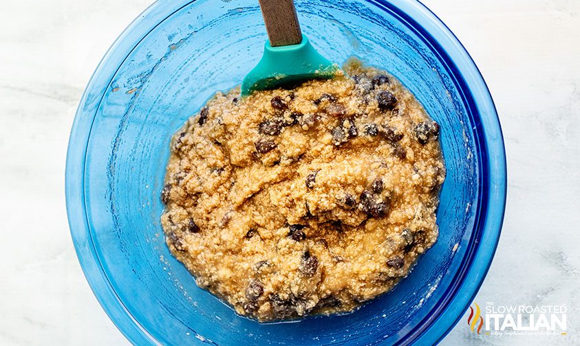 mixing applesauce cookie dough in a large blue bowl