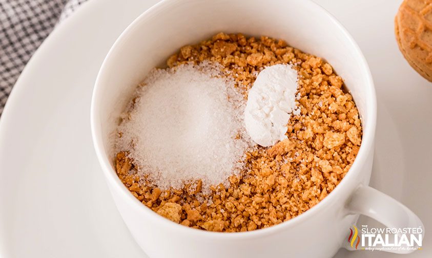 mug full of crushed peanut butter cookies, sugar, and baking powder