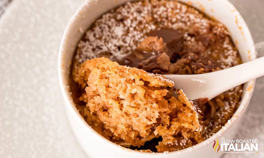 scooping peanut butter cake out of a mug