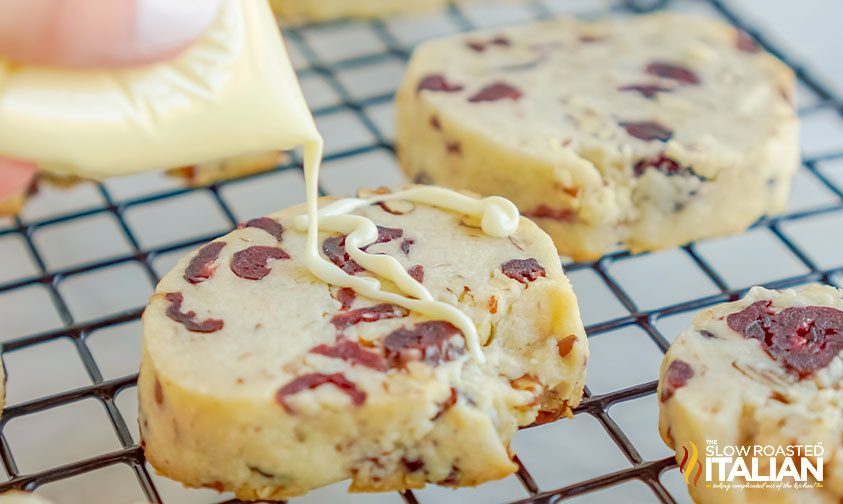 drizzling white chocolate over shortbread cookies