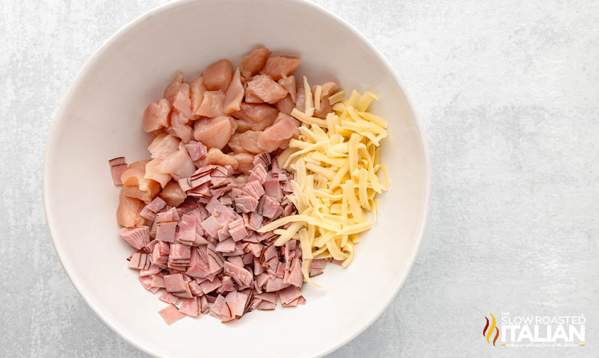 cubed chicken, ham and shredded cheese in a large mixing bowl