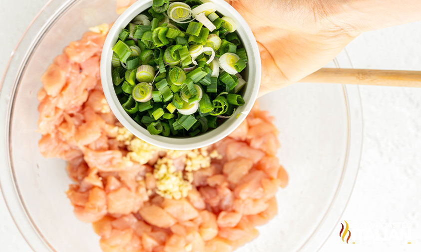 adding green onions to chicken mixture