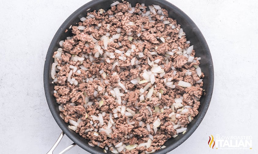 browned ground beef and chopped onions in a skillet