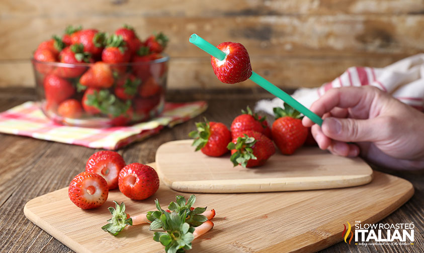 green straw passed through a strawberry