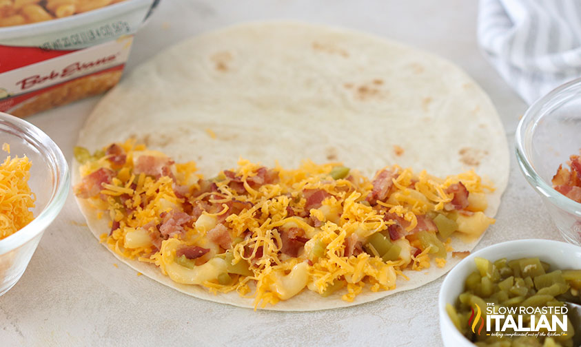 adding bacon, jalapenos and shredded cheddar cheese to mac and cheese quesadilla