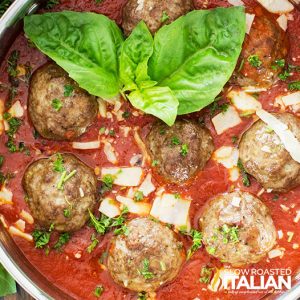 mozzarella stuffed meatballs in a skillet with red sauce