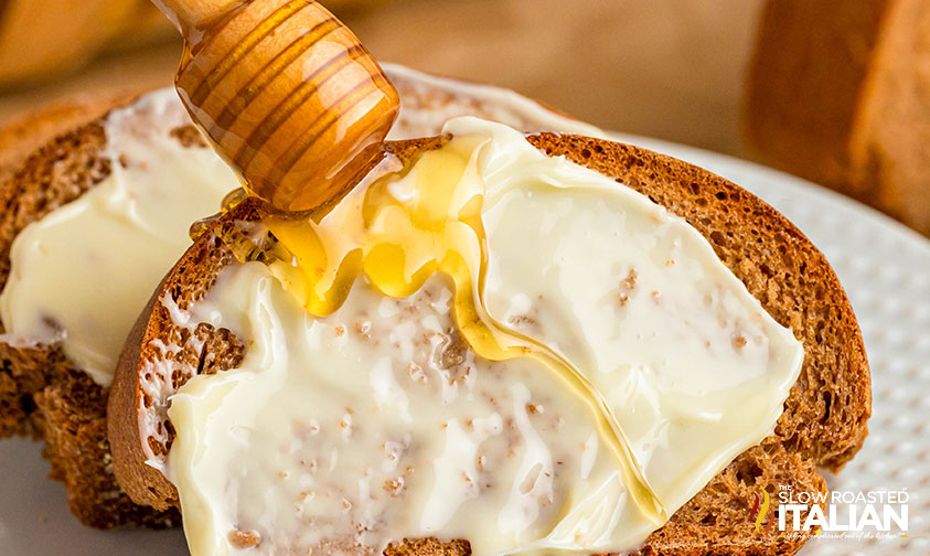 closeup of outback steakhouse bread slathered in butter with a drizzle of honey