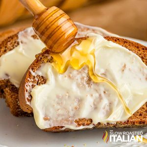 closeup of outback steakhouse bread slathered in butter with a drizzle of honey