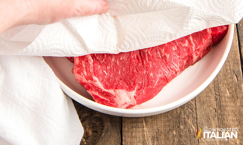 patting the ribeye steak with a paper towel