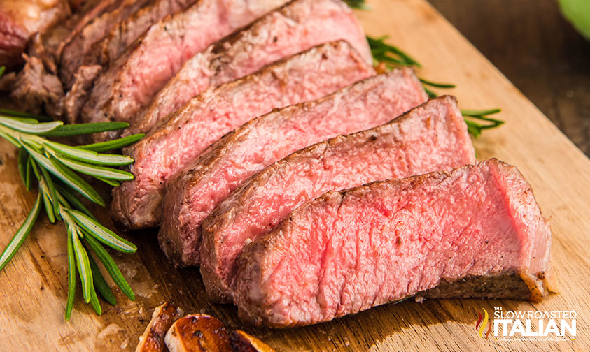 sliced cast iron ribeye steak on a cutting board