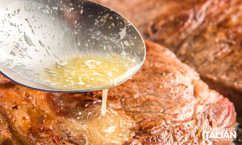 spooning butter over ribeye steak