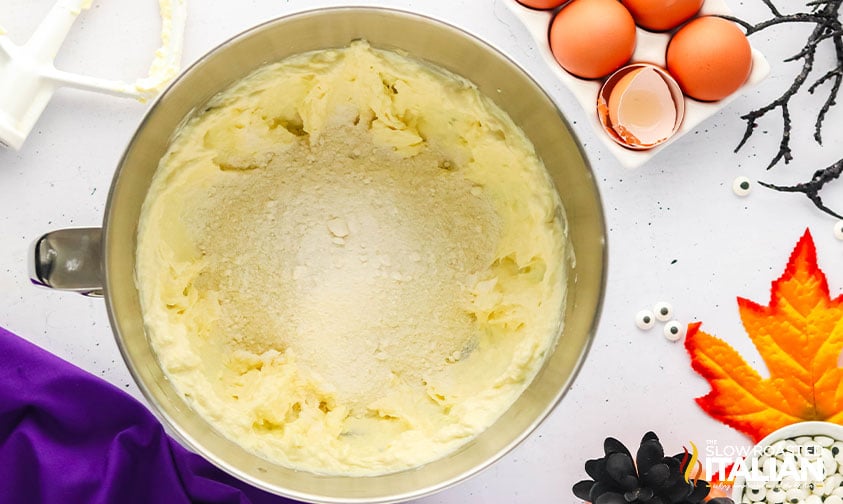 adding cake mix to creamed butter, cream cheese and eggs.