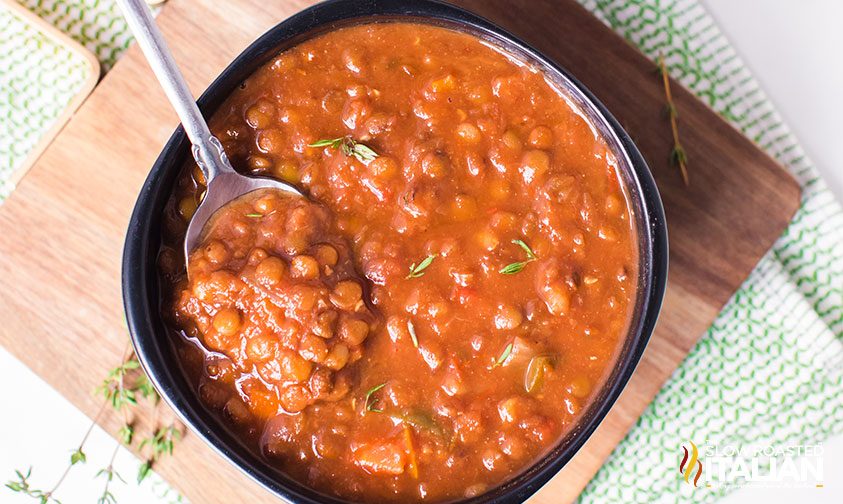 overhead: spoon in a bowl of hearty lentil soup