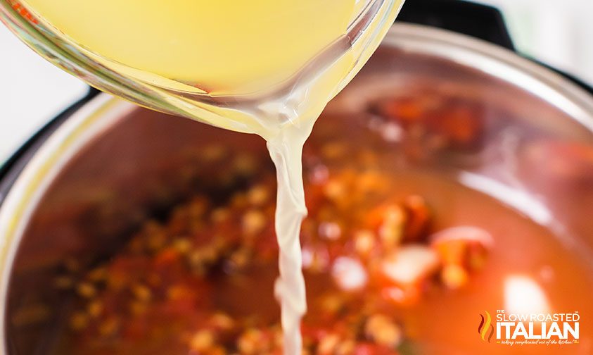 pouring broth into pressure cooker