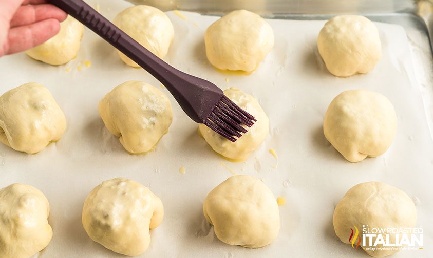 brushing rows of mini sloppy joes with egg wash