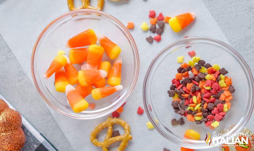 bowl of candy corn and bowl of leaf sprinkles on parchment paper