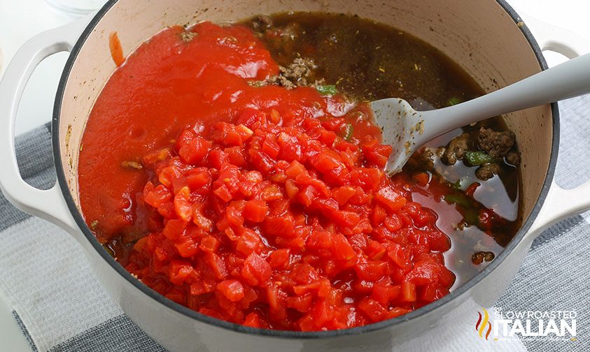 canned tomato sauce and diced tomatoes in pot of soup