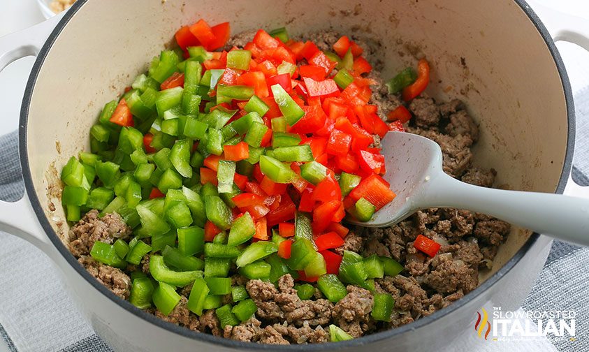 cooking ground beef and chopped bell peppers in pot