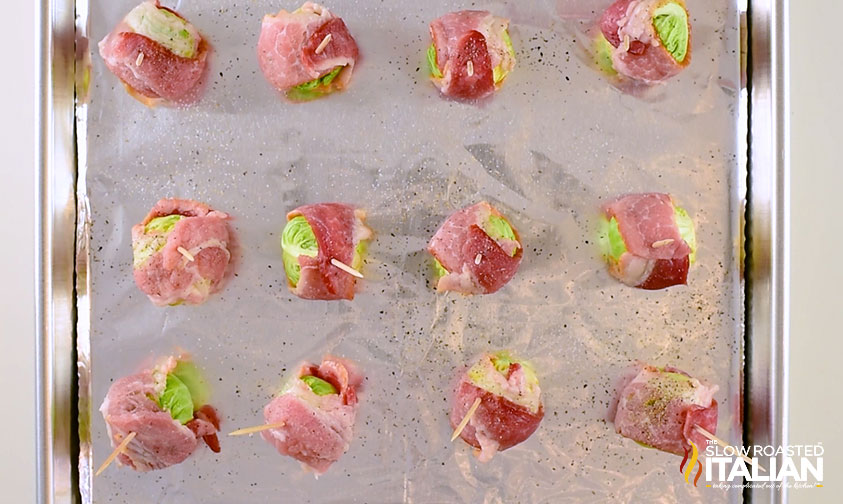 bacon wrapped brussel sprouts on a baking sheet