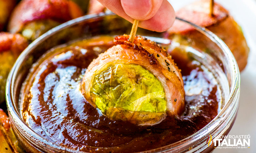 dipping bacon wrapped brussel sprouts in sauce