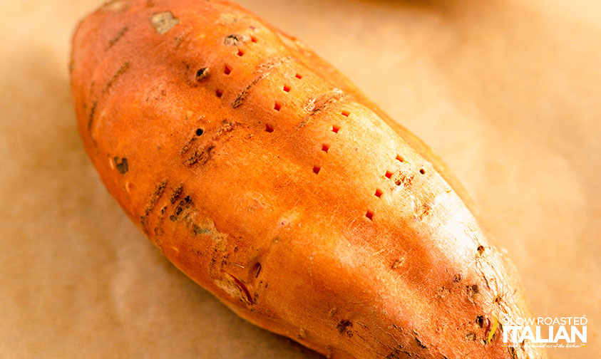 raw sweet potato with holes poked in skin