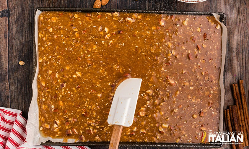 spreading toffee mixture on a baking sheet