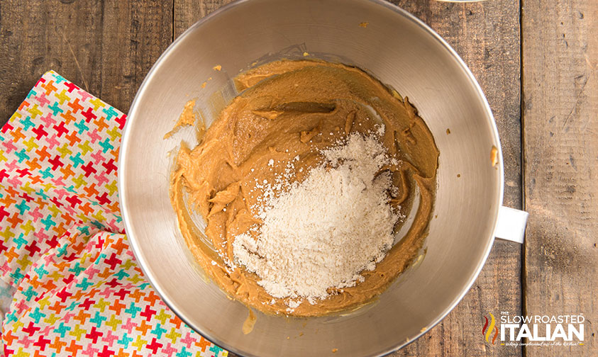 adding dry ingredients to wet ingredients in mixing bowl