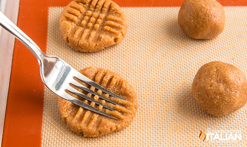 pressing keto peanut butter cookies down with a fork