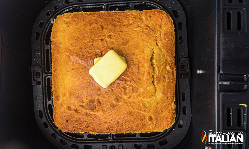 air fryer cornbread in air fryer basket with melting butter on top