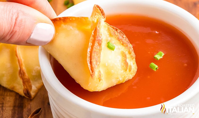 dipping air fryer cream cheese wonton in sweet and sour sauce