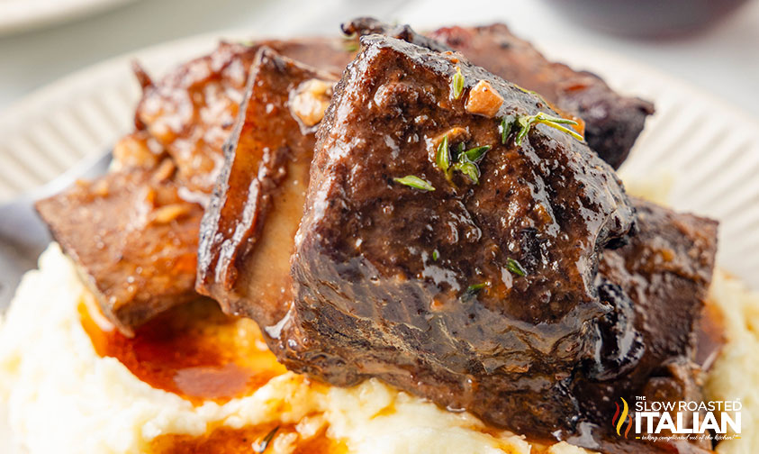 closeup of braised beef short ribs over mashed potatoes