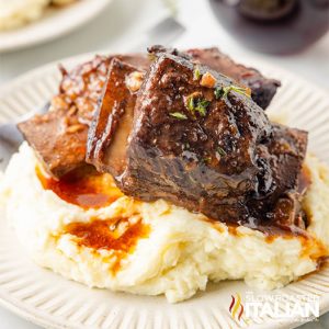 braised beef short ribs with mashed potatoes on a plate