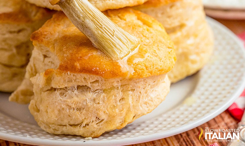 brushing cracker barrel biscuits with melted butter