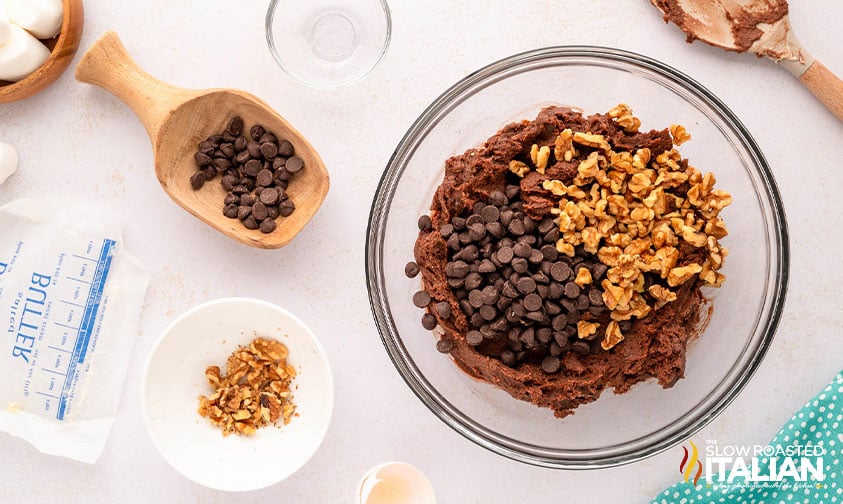 adding walnuts and chocolate chips to cookie dough