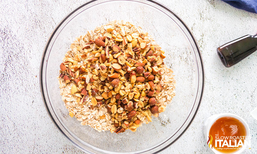 adding chopped mixed nuts to large mixing bowl