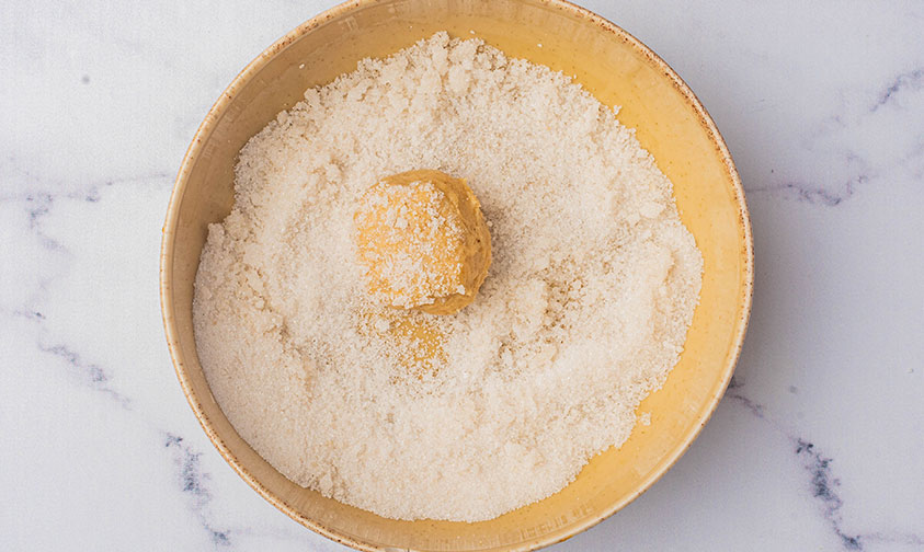 rolling ginger snap cookie dough in sugar