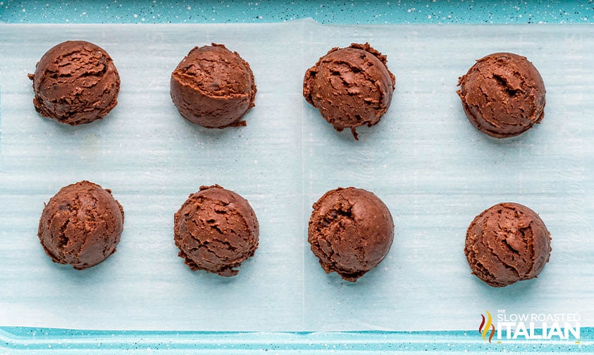 brownie bites scooped onto a parchment lined baking sheet