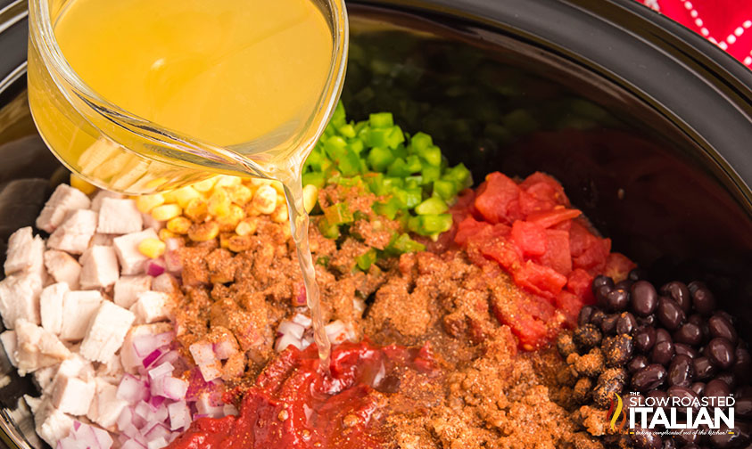 adding stock to turkey chili ingredients in crock pot