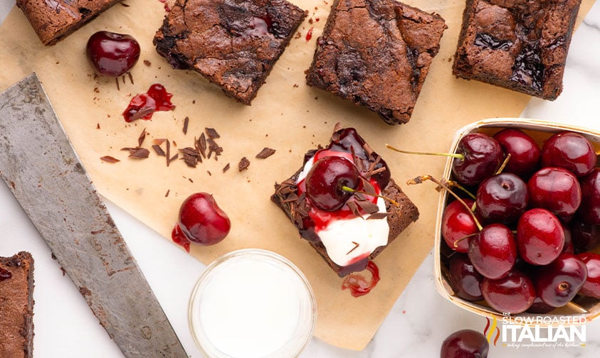 cherry brownies with a dollop of whipped topping and a fresh cherry on top