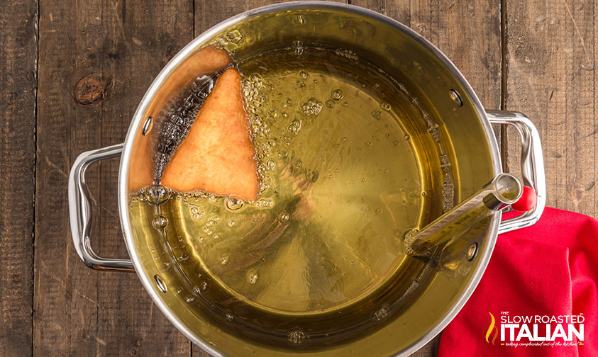 frying olive garden italian donuts in a large pot