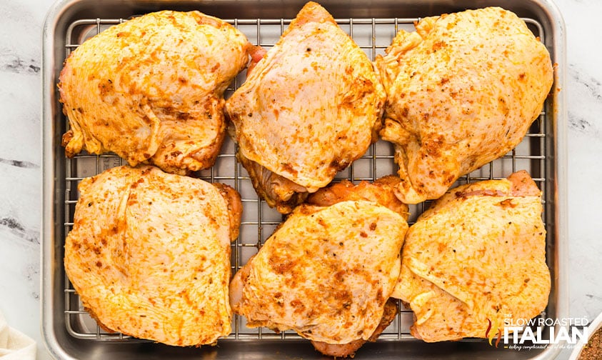 chicken thighs on a wire rack in baking sheet