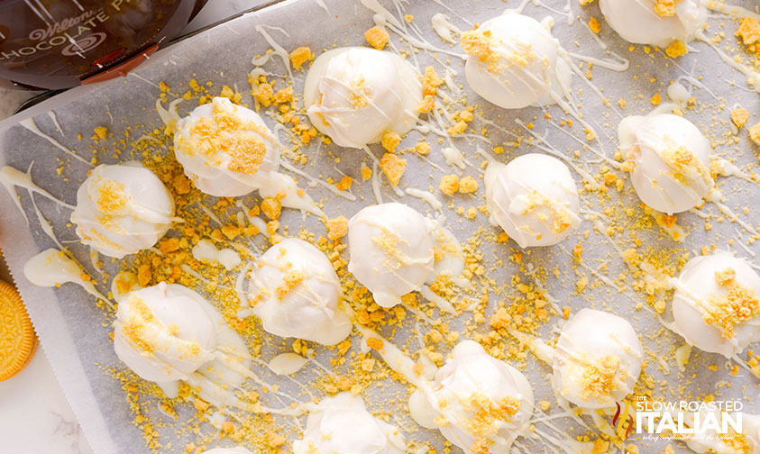 golden oreo truffles on a parchment lined baking sheet