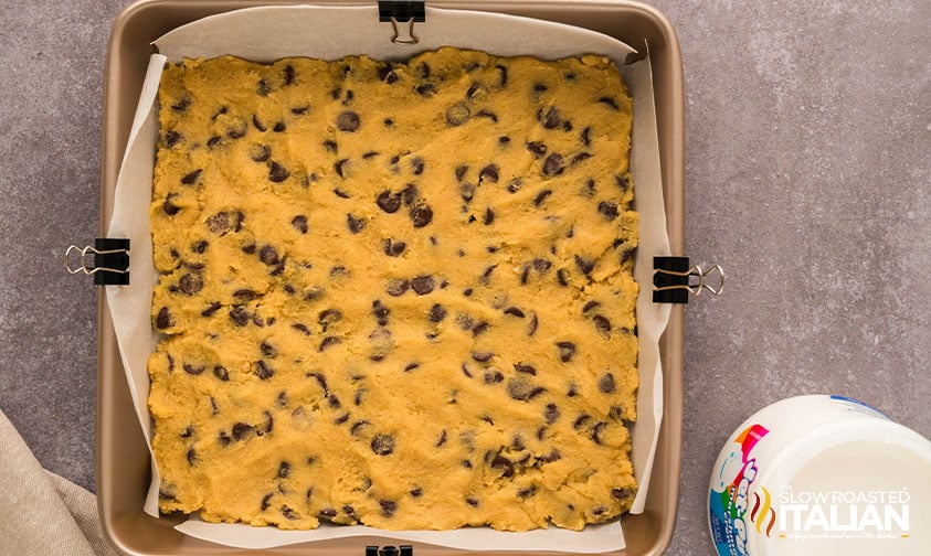 adding cookie dough layer to baking pan